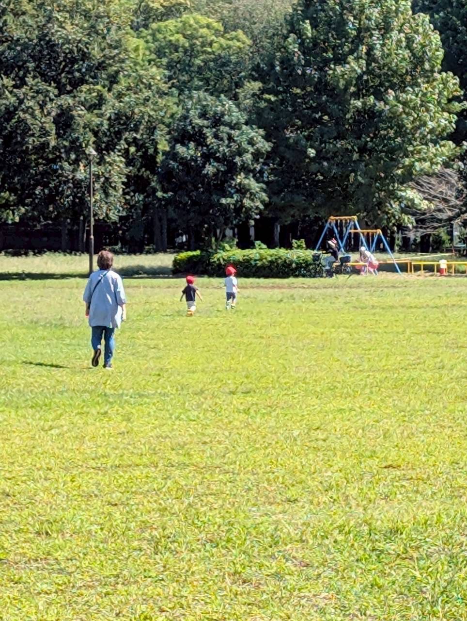先生と一緒に屋外で過ごす子どもたち